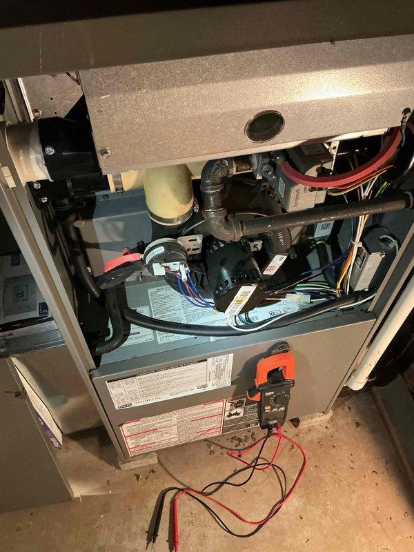 Responded to service call for 17-year-old gas furnace making noise. Performed diagnostic testing with clamp meter on electrical components, examining motor and internal wiring connections. Inspected adjacent water heater installation while on site to ensure proper ventilation and clearance between appliances.