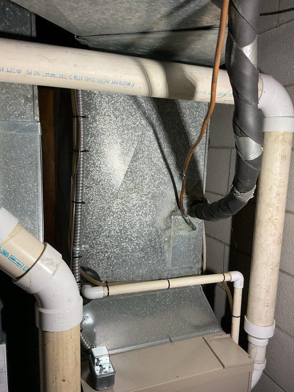 Performed comprehensive assessment of existing residential HVAC system and water heater installation in utility room. System features properly installed cylindrical water heater with copper piping connections, functioning valves, and associated PVC drainage components. Evaluation included inspection of the air handler unit, ductwork condition, and all mechanical connections to determine appropriate replacement options.