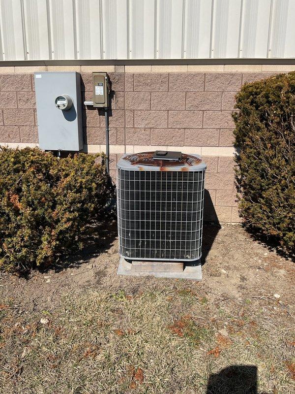 Conducted site assessment for furnace and heat exchanger replacement, documenting the existing outdoor AC condenser unit with proper electrical connections and disconnect switch. Evaluated the indoor Carrier HVAC system showing signs of aging with visible wall cracks nearby, noting the current ductwork configuration and PVC drainage/ventilation pipes that would need to be integrated with any new installation.