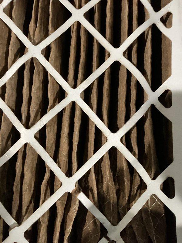 Responded to no-heat call for furnace of undetermined age. Inspection revealed heavily soiled air filter as primary issue, with significant dust and debris accumulation on the pleated filter elements. Replaced contaminated filter with new standard HVAC system filter to restore proper airflow and system operation.