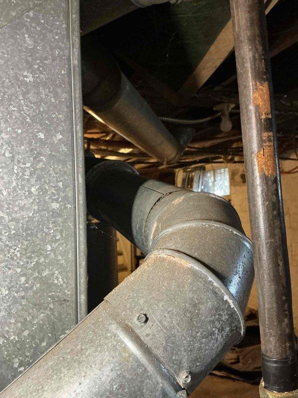 Responded to no-heat call for 15-year-old gas furnace that had ceased operation. Inspection of ductwork and ventilation system revealed significant dust accumulation and wear on galvanized steel components. Identified and repaired compromised joint connection in the drainage system, which had been previously addressed with temporary sealing materials.