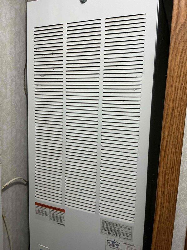 Performed scheduled heating maintenance service with focus on inspection of electric motor components and housing unit. Checked motor specifications, wiring connections and mounting integrity within the ventilation system. Examined wall-mounted heating unit with louvered panels for proper airflow and verified operational status.