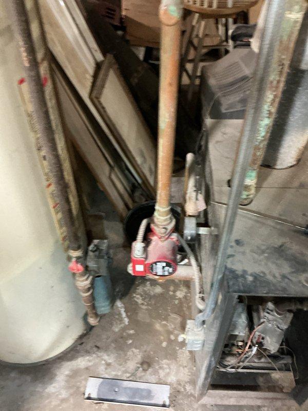 Responded to service call for non-functioning water boiler over 18 years old. Inspection revealed a circulation pump with significant corrosion on copper piping and green patina formation. Replaced failing circulation pump, cleaned mineral deposits, and verified proper system operation with all connections secure.