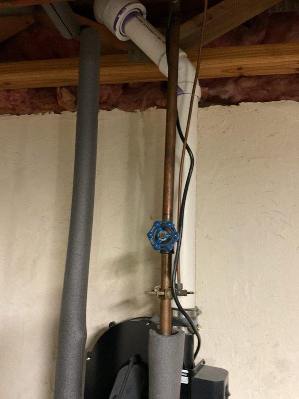 Conducted comprehensive assessment of existing water heater system and associated plumbing components. Identified aging copper supply lines with visible mineral deposits at connection points and documented current valve configuration including functional blue shutoff valve. Prepared detailed quote for replacement unit with financing options, documenting existing installation constraints with photographic evidence of utility area layout and current piping arrangement.