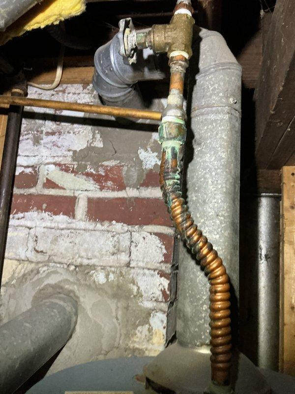Responded to service call for leaking valve on hot water tank. Upon inspection, identified corrosion on copper flex gas line with visible green patina and deterioration. Replaced faulty valve on hot water heater to eliminate drip leak and restore proper function.