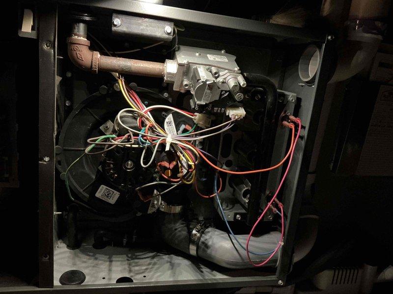 Performed scheduled maintenance on furnace unit located in attic space. Inspected interior components including blower motor assembly, gas valve, wiring harness, and drainage system; all components found in normal operating condition. Documentation photos taken of complete system installation and internal components for service records.