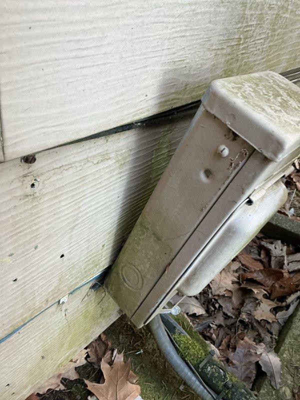 Performed scheduled AC tune-up on Ruud outdoor unit. Inspected electrical connections at junction box and noted weathering with visible moss/mildew growth on both the box and adjacent siding. Unit was operational but showing signs of age with dirt accumulation on exterior surfaces; cleaned accessible components and verified proper system function.
