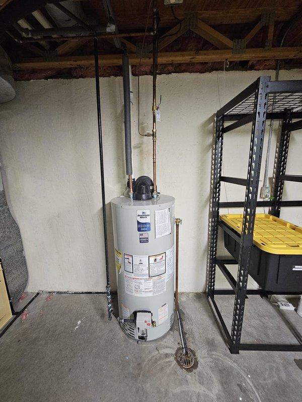 Successfully installed a 50-gallon Bradford White power vent water heater in the basement utility area. Connected copper and PVC piping with proper venting, and verified the shut-off valve location to the right of the tank in the corner. Unit was tested and confirmed to be functioning according to manufacturer specifications.