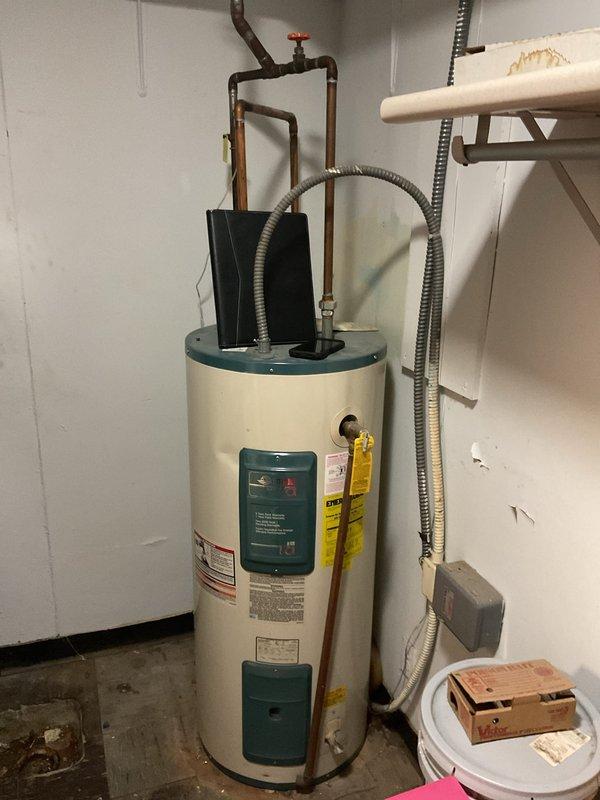 Conducted assessment of commercial water heater requiring replacement. Inspection revealed significant deterioration of internal insulation with visible discoloration around control area. Unit shows signs of wear with damaged yellow insulation material exposed through access panel, indicating potential safety and efficiency concerns that warrant full replacement rather than repair.