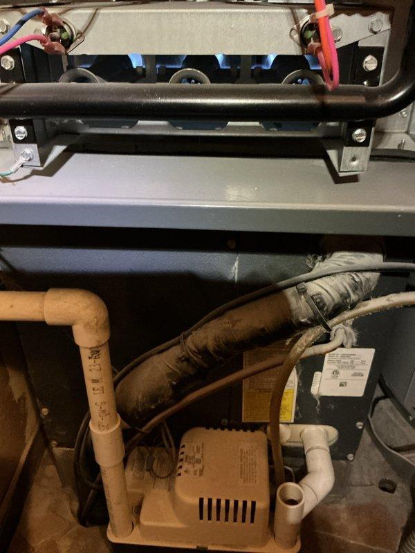 Performed comprehensive furnace tune-up on 7-year-old system. Inspected interior components including electrical connections, PVC venting, and pump assembly. Measured register temperature (69°F) using digital testing equipment to verify proper system operation.