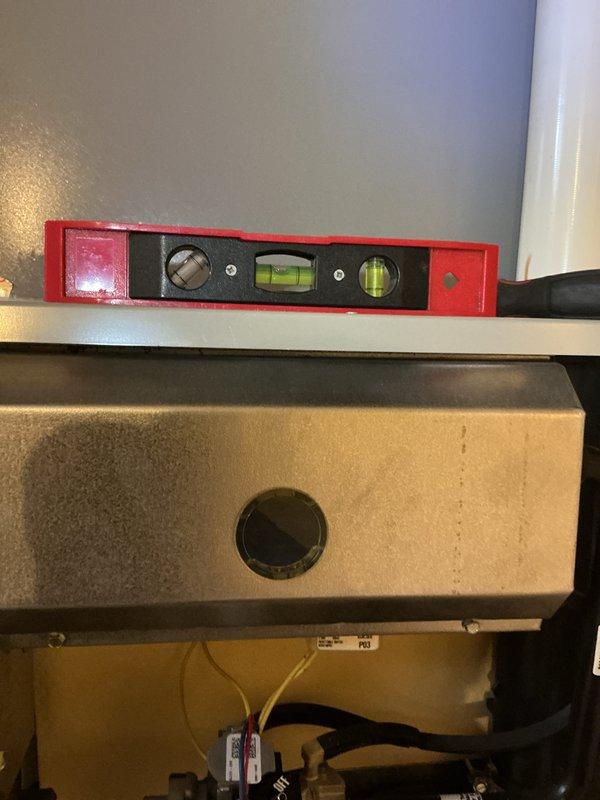 Performed scheduled heating maintenance on HVAC system. Inspected motorized valve assembly with ON/OFF actuator and verified proper electrical connections to control wiring. Confirmed unit leveling using torpedo level on equipment housing to ensure optimal operation of system components.