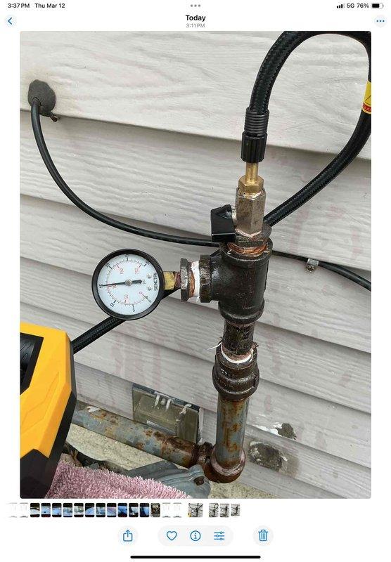 Completed gas line repair work in basement by water heater and washer/dryer area as requested. Performed pressure testing using gauge assembly to verify system integrity, with testing showing no leaks present. Documented repair with photos showing pressure test equipment and connections.