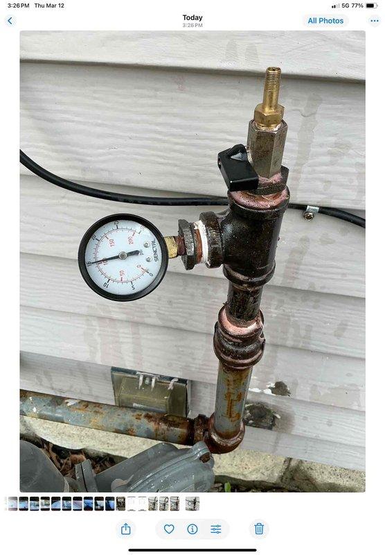 Completed gas line repair work in basement by water heater and washer/dryer area as requested. Performed pressure testing using gauge assembly to verify system integrity, with testing showing no leaks present. Documented repair with photos showing pressure test equipment and connections.