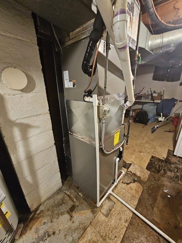 Completed installation of a new 96% efficient 70kBtu upflow furnace to replace old Lennox Pulse unit, requiring metal spacer modification for proper fitment. Installation also included a 12-gallon humidifier, 40-gallon water heater, and upgraded thermostat from T1 to Honeywell T6 Pro, with all systems properly connected to existing ductwork and properly vented with PVC piping.