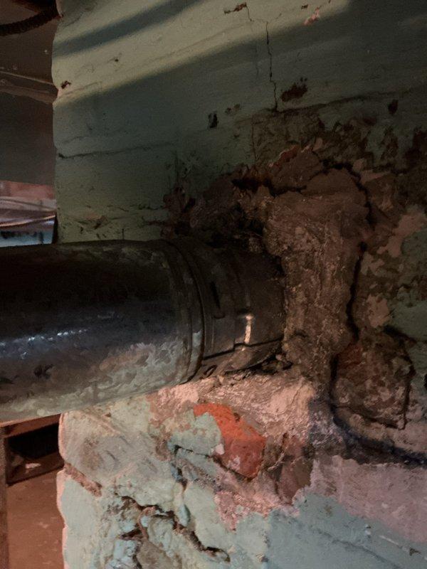 Conducted water heater installation estimate in utility area, documenting existing copper piping with brass shutoff valve showing signs of age and mineral buildup. Noted significant wall damage around pipe penetration point with crumbling material and extensive cracking, indicating possible previous water damage that will need to be addressed during installation.