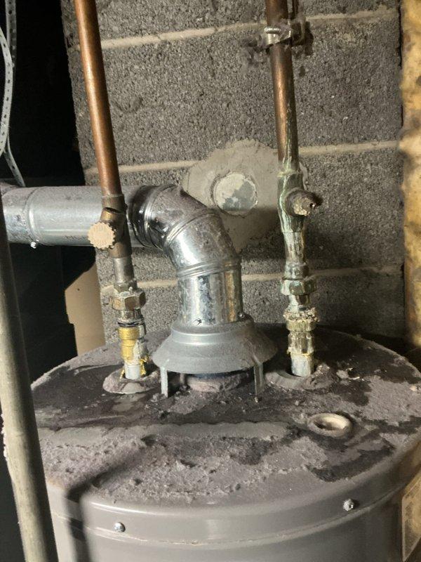 Responded to service call for 5-year-old natural gas water heater with pilot light failure causing no hot water. Upon inspection, found significant dust accumulation on tank and mineral buildup around pipe connections. Successfully cleaned pilot assembly and reignited pilot light, restoring proper water heater function.
