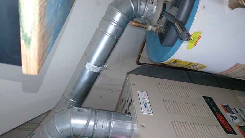 Responded to service call for a 10+ year old natural gas water heater exhibiting operational issues. Upon inspection, observed an aging tank-style water heater with copper supply lines and proper venting connections to the adjacent HVAC system. Diagnostic assessment revealed end-of-life conditions requiring replacement recommendation due to age and declining performance.