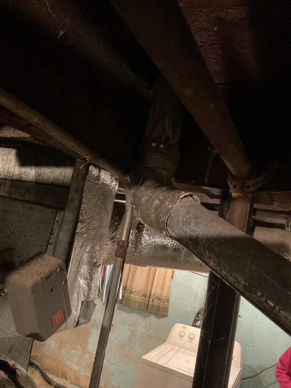 Provided estimate for replacement of 50-gallon water heater in basement utility area. Inspection revealed aging unit with visible corrosion on galvanized elbow joint and mineral deposits around connections. Noted existing copper supply lines with valve and evaluated current installation configuration for proper replacement.