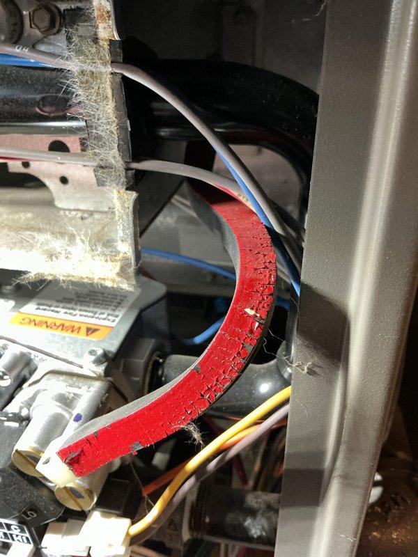 Performed routine furnace tune-up on an older wall-mounted furnace unit. Inspection revealed deteriorating door gasket with visible cracking and dust accumulation. System was cleaned, components checked for proper operation, and recommendations made for gasket replacement to maintain optimal efficiency.