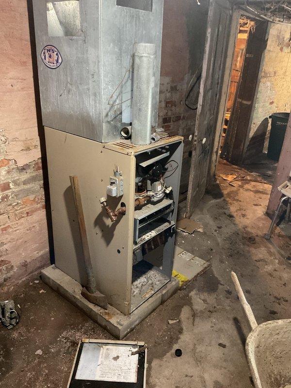 Conducted estimate for installation of new ductwork and replacement of severely deteriorated furnace system. Current unit shows significant age with exposed internal components and is located in a basement area with extensive cobweb accumulation, exposed brick walls, and poor maintenance conditions. Recommended complete system replacement and proper ductwork installation to improve heating efficiency and safety.