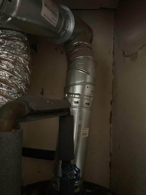 Assessed and documented a non-functional hot water tank in century-old residence requiring full replacement. Observed outdated plumbing requiring code compliance upgrades, with particular attention to existing HVAC ductwork connections and confined utility space constraints. Photographed current installation to facilitate proper replacement planning, noting significant age deterioration and potential ventilation system modifications needed.