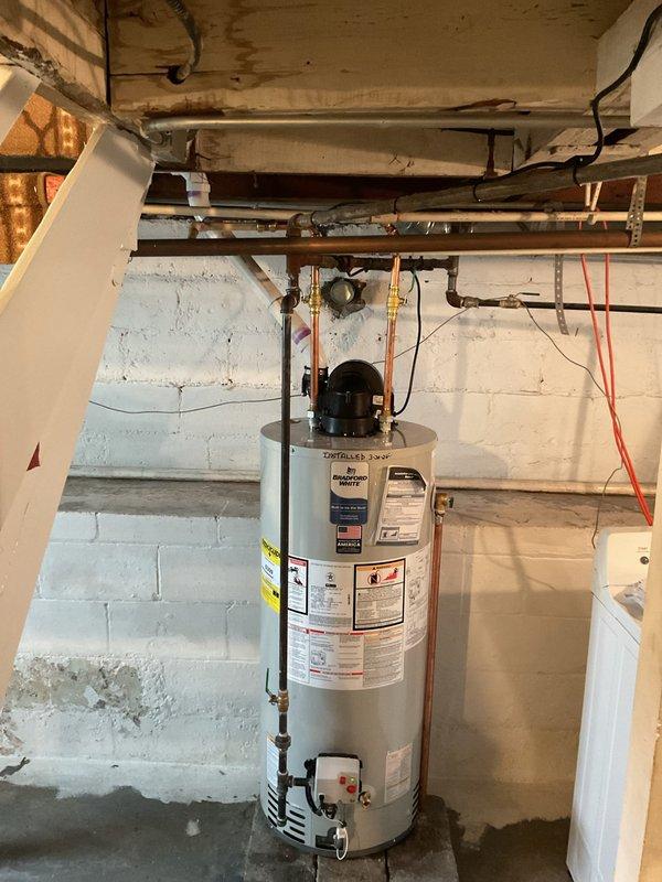 Successfully installed a new 40-gallon power vent water heater in basement utility area, properly connecting all copper supply lines and PVC venting. Capped off existing flue pipe as requested and verified all connections for proper operation.