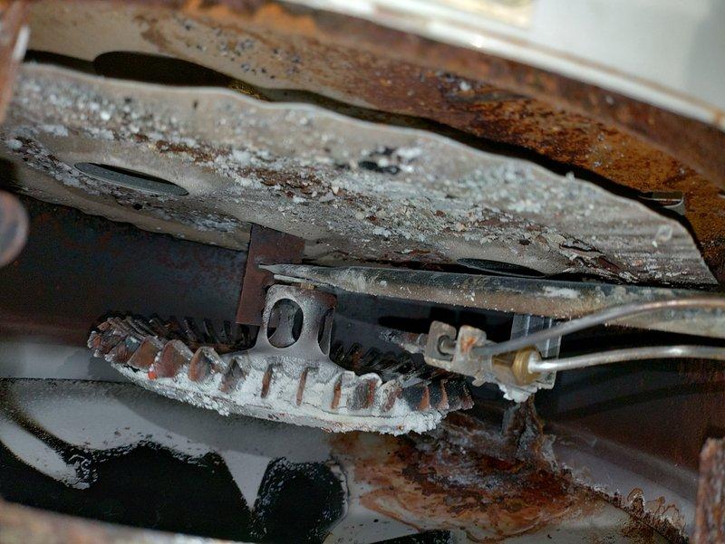 Responded to service call for 27-year-old gas water heater experiencing flame roll-out condition. Upon inspection, discovered severely corroded burner assembly and heat exchanger components with extensive rust deterioration and white crystalline deposits indicative of combustion byproduct accumulation. The flame roll-out condition posed immediate safety hazard due to compromised combustion chamber integrity and improper venting of exhaust gases. Documented extensive corrosion throughout burner components and recommended immediate replacement of unit due to age, advanced deterioration, and safety concerns that cannot be adequately addressed through repair.