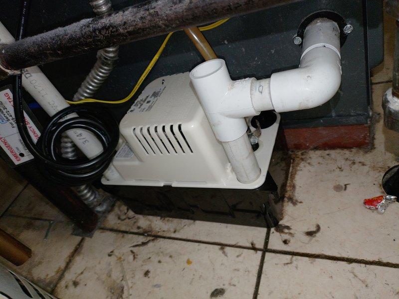 Responded to no-heat call for 10-year-old furnace unable to maintain temperature above 61-64 degrees. Inspected HVAC system including furnace unit, condensate pump assembly, and associated drainage components. Verified proper installation of condensate removal system with PVC piping connections and confirmed operational status of mechanical equipment in utility space.