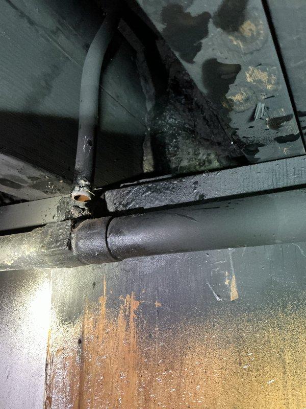 Responded to boiler pipe failure with immediate system shutdown and drain-down to prevent further water damage. Assessed broken piping configuration, identifying ceiling-mounted pipe as 1.25 to 1.5 inch diameter and vertical riser as approximately 5/8 inch diameter, though measurements complicated by multiple paint layers. Documented extensive corrosion, rust staining, and moisture damage throughout system components via photo documentation. Provided temporary heating solution with two electric space heaters to maintain building comfort during repair period. Scheduled follow-up appointment to complete pipe repair using pro-press connection method.
