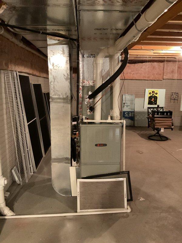 Completed comprehensive evaluation of existing residential HVAC system for full replacement estimate. Documented current equipment including basement-installed furnace unit with evaporator coil and outdoor cylindrical condenser unit. Assessed ductwork configuration, air filtration components, and condensate drainage system. Photographed all major equipment and installation conditions to provide accurate replacement specifications and system sizing recommendations.