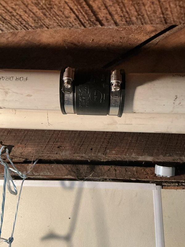 Completed warranty AC system startup and commissioning. Verified proper condensate drain line installation with PVC piping and flexible coupling connections, confirming secure mounting and leak-free operation. Performed airflow measurements at supply ductwork, recording 55.4 CFM readings to validate system performance meets manufacturer specifications. System operational and functioning within normal parameters.