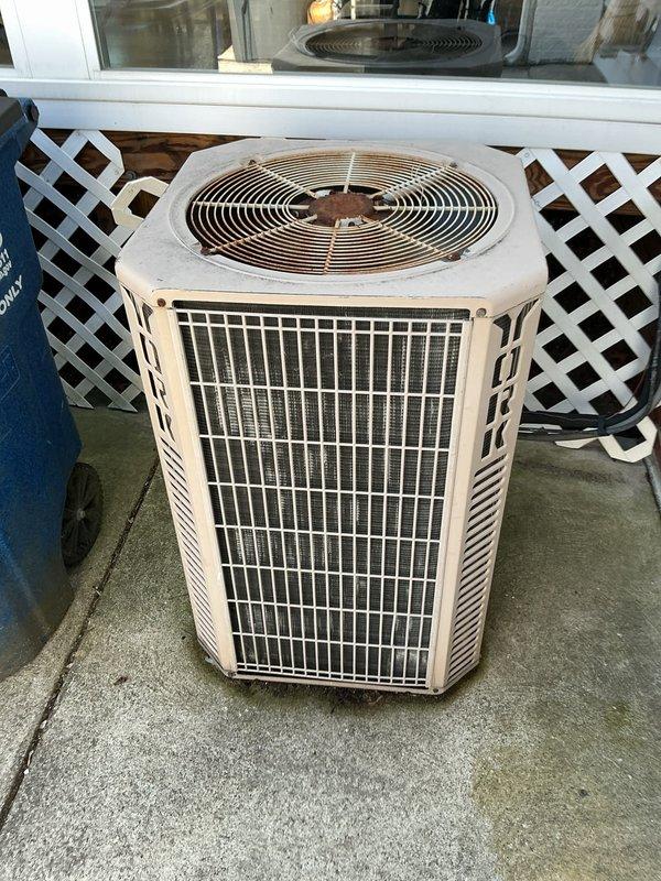 Completed MVP cooling maintenance visit on residential air conditioning system. Performed comprehensive inspection of outdoor condensing unit, noting significant rust deterioration on fan motor housing and compressor components with visible water accumulation in unit interior. Documented unit condition with photographs showing aged condenser positioned on concrete pad with weathered housing and functional wire grille protecting heat exchanger coils. Unit operational at time of inspection despite visible corrosion on internal components.