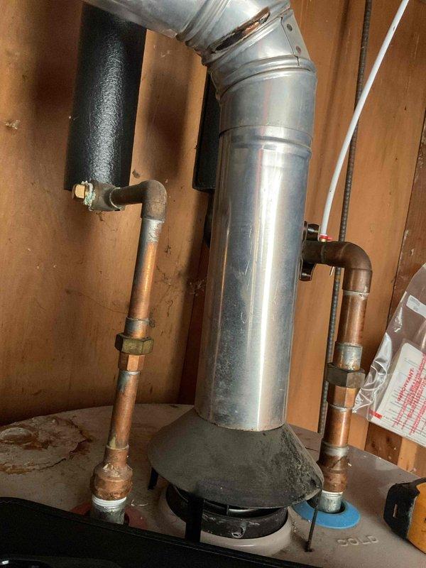 Conducted comprehensive water heater replacement estimate at residential property. Assessed existing water heater installation including galvanized steel flue vent system with vertical run and elbow configuration, copper supply and distribution piping with brass shut-off valves, and current mounting platform. Documented plumbing connections, venting arrangement, clearances to combustible materials, and proximity to concrete block foundation wall. Photographed existing installation showing foam pipe insulation on hot water lines, galvanized vent pipe condition with visible wear, and copper piping with aged patina. Evaluated accessibility for equipment removal and replacement within unfinished utility space with exposed wall studs. Noted existing valve locations, pipe sizing, and connection points for new unit installation. Provided detailed assessment for complete water heater replacement including removal of existing unit, installation of new water heater with proper venting, connectio
