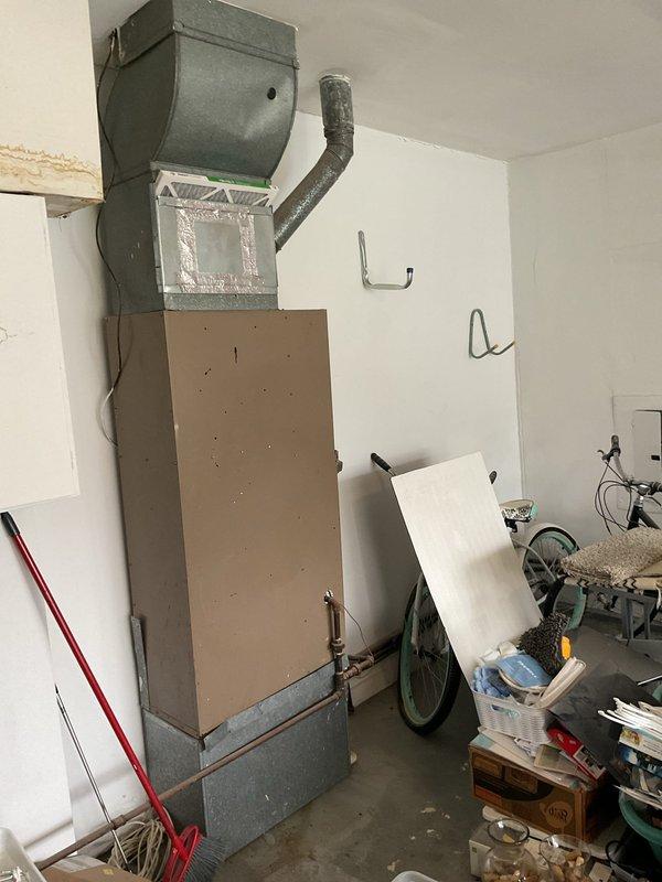 Conducted comprehensive assessment of existing residential HVAC system for complete replacement, including outdoor condensing unit on concrete pad and indoor air handler/furnace assembly located in garage. Evaluated current equipment condition, ductwork configuration, refrigerant line routing, electrical service connections, and installation accessibility. Documented existing system specifications and photographed both exterior and interior components to provide accurate replacement recommendations and ensure proper equipment sizing for the home's heating and cooling requirements.