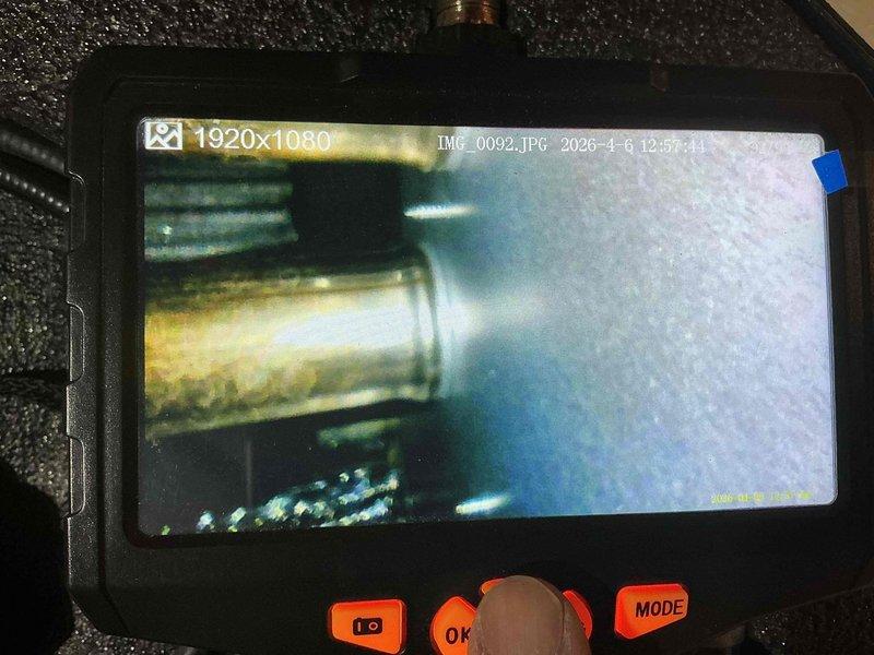 Responded to no heat call where customer reported burning plastic smell from furnace the previous night. Upon inspection, discovered severely corroded heat exchanger with visible deterioration and surface oxidation. Used borescope camera to document internal damage to heat exchanger cells, confirming multiple areas of concern that posed potential safety hazard. Removed and photographed damaged heat exchanger section showing significant corrosion on copper-colored metal surfaces. Recommended furnace replacement due to failed heat exchanger and age of unit. System tagged out of service for safety until replacement can be completed.