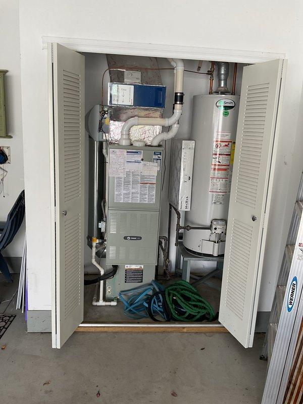 Conducted comprehensive HVAC system evaluation for complete equipment replacement. Assessed existing indoor furnace unit located in utility closet alongside water heater, noting current ductwork configuration with flexible connections and PVC condensate drainage system. Evaluated outdoor Trane air conditioning unit positioned on exterior of residence with existing electrical disconnect and refrigerant line set routing along siding. Documented equipment specifications, clearances, and installation parameters. Photographed current system layout including indoor air handler placement, utility closet dimensions, ductwork connections, and outdoor condenser location within landscaped area. Reviewed electrical service requirements and existing condensate drain routing. Prepared detailed replacement estimate for new high-efficiency HVAC system including equipment specifications, installation requirements, and necessary modifications to existing infrastructure.