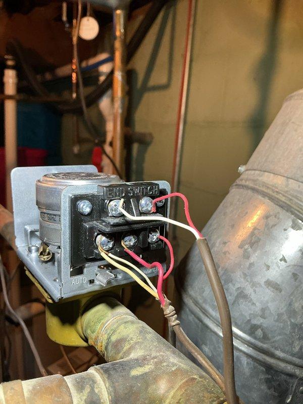 Responded to service call for over 13-year-old boiler system with one zone failing to shut off properly. Upon inspection, identified potential thermostat control issues affecting zone operation. Examined Honeywell control module and associated wiring connections, inspected zone valve with red gate valve handle and electronic sensor assembly, and documented existing copper piping system showing age-related corrosion and patina. Recommended thermostat evaluation and potential replacement to resolve continuous operation issue in affected heating zone.