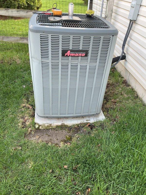 # HVAC Maintenance - Cooling

Performed comprehensive preventive maintenance on residential Amana air conditioning condenser unit. Upon arrival, conducted visual inspection revealing significant dirt and debris accumulation on condenser coil with heavy dark streaking and clogged aluminum fins, which was substantially reducing system efficiency and airflow capacity.

Removed top grille and access panels to gain full access to internal components. Thoroughly cleaned condenser coil using specialized coil cleaner and low-pressure water rinse to remove built-up contamination from aluminum fins. Inspected compressor unit and refrigerant lines, noting white residue on compressor casing and housing panels. Verified all copper refrigerant lines and connections for proper insulation and secure fittings.

Checked electrical connections and wiring harness for signs of wear or corrosion. Confirmed electrical disconnect box operation and proper conduit installation. Reassembled unit with all panels 
