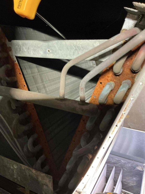 Completed comprehensive AC tune-up on residential cooling system at two properties. Performed standard maintenance protocol including inspection of evaporator coil assembly, air handler components, and refrigerant lines. Notable findings included significant rust and corrosion on metal brackets, mounting plates, and ductwork seams, indicating moisture exposure and age-related deterioration. Documented equipment condition with photos showing oxidation on structural elements while refrigerant lines remain in serviceable condition. System operational upon completion of tune-up procedures.