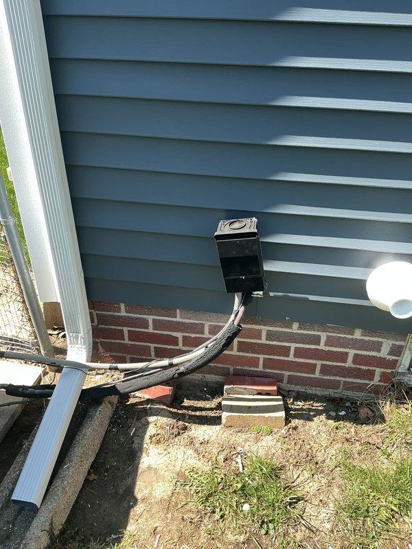 Responded to no cooling complaint at residential property. Upon arrival, contacted customer as requested prior to entry. Performed diagnostic inspection of air conditioning system with unknown age. Documented existing HVAC installation including furnace unit with PVC venting system and metallic ductwork in basement utility area. Inspected exterior condensing unit location at foundation level. Captured photographic documentation of equipment and installation for service records.