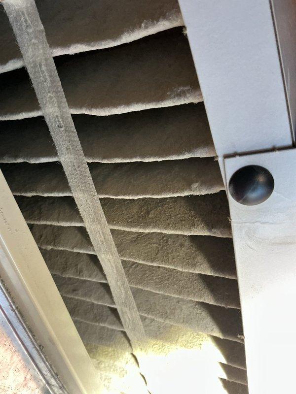 Performed scheduled air conditioning maintenance on unknown age system. Upon inspection, found evaporator coil fins with moderate to heavy dust and debris accumulation affecting airflow efficiency. Noted physical damage to upper section of coil assembly with bent and torn fins requiring attention. Documented condition of heat exchanger components showing signs of extended service life, including weathered copper support grid with patina buildup and white residue coating on fin surfaces. Completed standard maintenance procedures and provided photographic documentation of system condition for customer records.