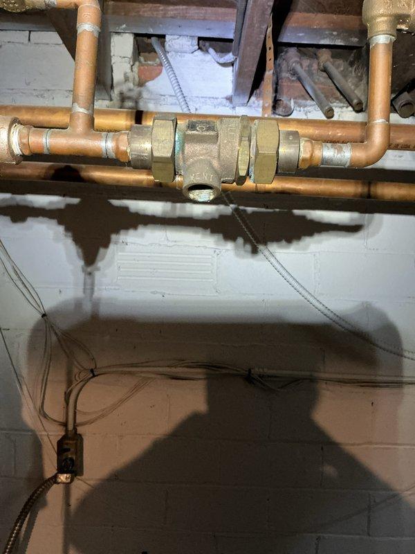 Completed scheduled boiler maintenance inspection responding to early morning service call. Performed comprehensive system evaluation including examination of copper supply piping, brass valve assemblies, and associated plumbing connections. Documented existing corrosion and mineral buildup on vertical valve assembly and oxidation present on horizontal copper piping throughout the mechanical space. All findings photographed for service records and system maintained according to manufacturer specifications.