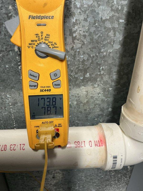 Installed heat shield for furnace to protect surrounding components from excessive heat exposure. Inspected heat exchanger fins using borescope camera, noting accumulated debris and discoloration on metallic surfaces. Verified system operation with multimeter readings showing 173.8V and temperature at 78.7°F, confirming proper electrical function and airflow after installation.