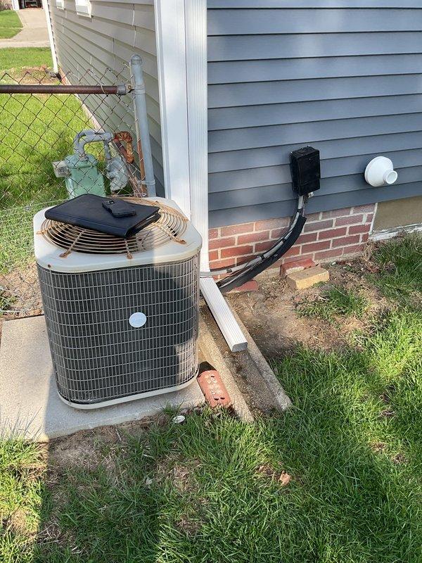 Completed comprehensive air conditioning system estimate for residential HVAC replacement. Evaluated existing outdoor condensing unit with tan cylindrical casing positioned on concrete pad alongside building exterior, noting current equipment specifications and installation configuration including electrical disconnect and conduit routing. Assessed indoor basement equipment including existing furnace unit with PVC venting system installed adjacent to water heater in mechanical room. Documented current system layout, equipment age and condition, electrical connections, refrigerant line routing, and ductwork configuration. Provided detailed replacement options and recommendations for complete HVAC system upgrade to improve efficiency and reliability.