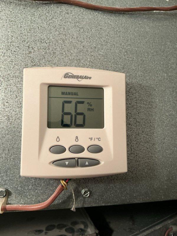 Completed preventative maintenance service on a 15-year-old air conditioning system. Performed comprehensive system inspection including examination of electrical components, contactor assembly, and humidity control equipment. Verified proper operation of GeneralAire digital humidity controller, which displayed 66% RH in manual mode. Inspected contactor relay assembly within electrical enclosure, noting multiple wire connections in good working condition despite age of system. Checked all electrical connections, copper refrigerant lines, and mounting hardware for security and proper installation. System operational upon completion of service visit.