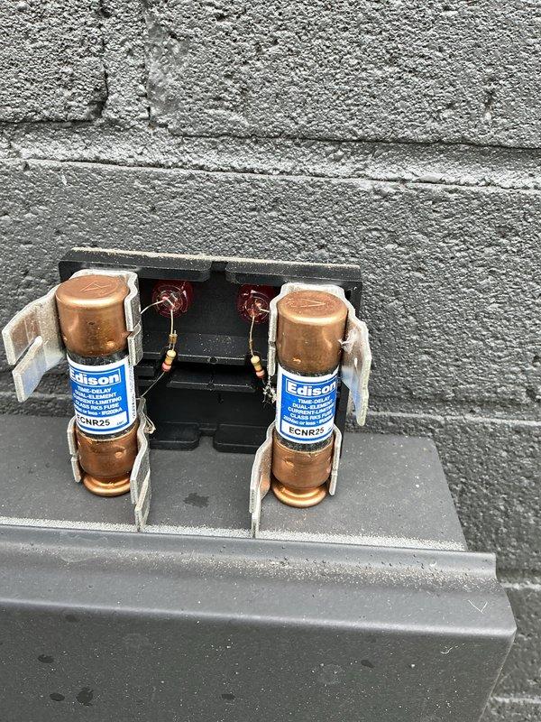 Completed cooling maintenance inspection on multi-unit HVAC system with four outdoor condensing units. Inspected electrical disconnect boxes and fuse assemblies, documenting condition of Edison-type ECNR25 fuses, terminal connections, and associated wiring at each unit location. All electrical components, terminal blocks, and safety disconnect switches were verified for proper operation and secure connections.