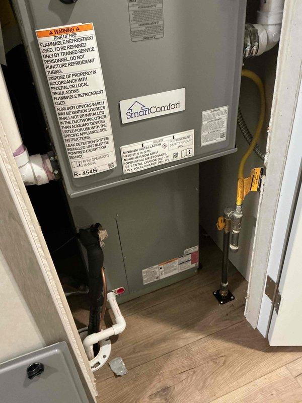 Responded to no cooling call on SmartComfort HVAC system. Upon arrival, performed diagnostic evaluation of the unit and measured system pressures and temperatures using refrigerant manifold gauge. Found system operating with R-454B refrigerant at 86 PSI suction and 88 PSI discharge pressure with subcooling readings indicating potential refrigerant charge issue. Verified system operation and documented equipment condition with proper labeling visible including flammable refrigerant warnings. System restored to proper cooling operation.