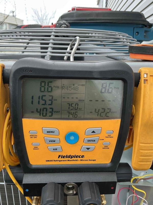 Responded to no cooling call on SmartComfort HVAC system. Upon arrival, performed diagnostic evaluation of the unit and measured system pressures and temperatures using refrigerant manifold gauge. Found system operating with R-454B refrigerant at 86 PSI suction and 88 PSI discharge pressure with subcooling readings indicating potential refrigerant charge issue. Verified system operation and documented equipment condition with proper labeling visible including flammable refrigerant warnings. System restored to proper cooling operation.