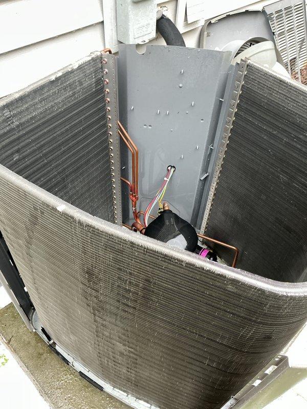 # HVAC Maintenance - Cooling

Performed routine maintenance inspection on a 4-year-old residential air conditioning system. Accessed outdoor condensing unit, removed top panel to inspect internal components including condenser coils, refrigerant lines, and electrical connections. Both heat exchanger coils showed normal operational condition with typical accumulation of outdoor debris around unit base. Verified copper refrigerant lines and electrical wiring connections were secure and functioning properly. Unit exterior showed normal weathering consistent with age and outdoor exposure. All components appeared operational with no immediate repairs required at time of service.