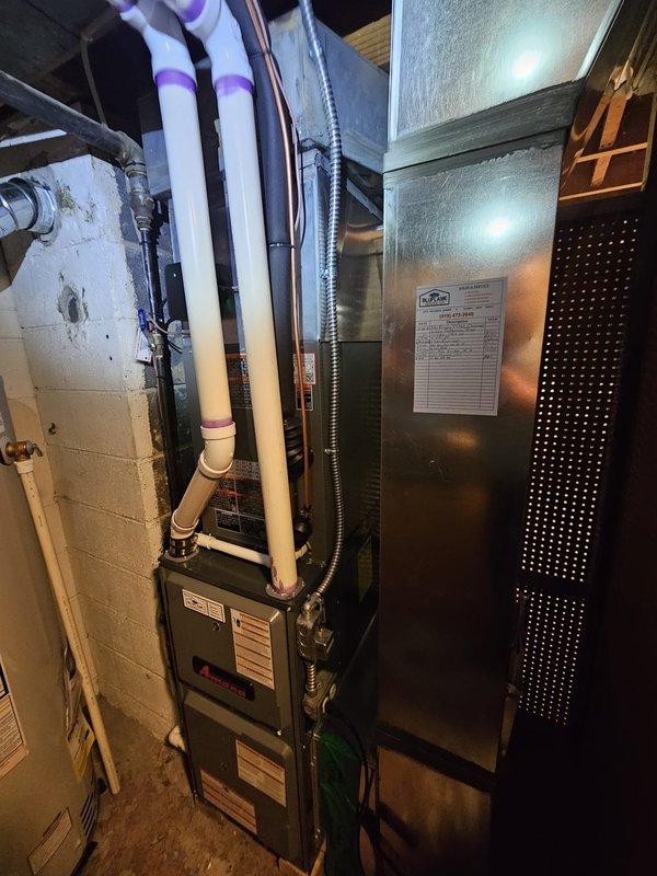 Completed installation of a 2-ton AC package unit with new coil system. Relocated and leveled existing equipment pad to proper position for optimal unit placement. Installed new 3/4-inch copper lineset spanning 15 feet with proper insulation, connecting outdoor condenser to indoor air handler. Ran refrigerant lines along foundation with secure mounting and proper service valve installation. Integrated Honeywell Wi-Fi thermostat for remote temperature control and system monitoring. Indoor installation includes air handler unit positioned adjacent to existing Amana furnace in basement mechanical room, with appropriate electrical conduit and wiring connections. System fully charged, tested for proper operation, and verified all connections for leak-free performance.